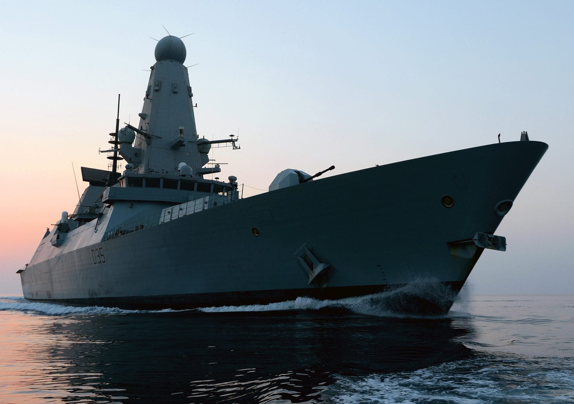 HMS Dragon ship at sea with sunset in the background