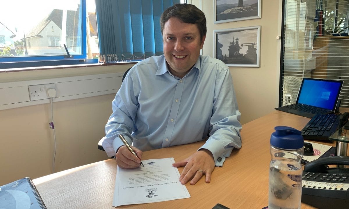AGI Managing Director officially signing Armed Forces Covenant document